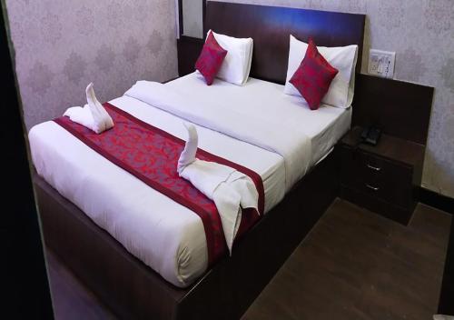 a bedroom with a large bed with red and white pillows at Sai Sharan Stay Inn- Near MIDC Turbhe Navi Mumbai in Navi Mumbai