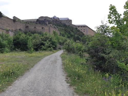 a dirt road with a castle on the hill at À Deux Pas ... in Briançon