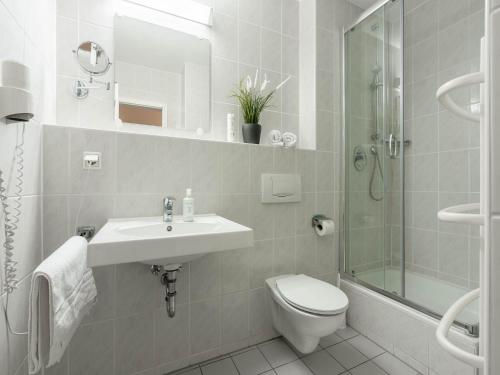 a bathroom with a sink and a toilet and a shower at Feriendorf Rugana - Komfort Appartement mit 1 Schlafzimmer und Terrasse B16 in Dranske