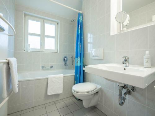 ein weißes Badezimmer mit Toilette und Waschbecken in der Unterkunft Feriendorf Rugana - Klassik Appartement mit 2 Schlafzimmern und Terrasse D01 in Dranske