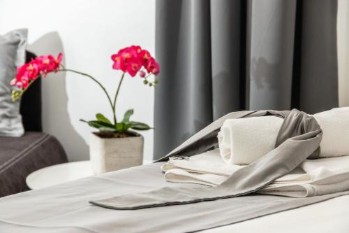 a bed with towels and flowers in a room at Prima Luxury Rooms in Split