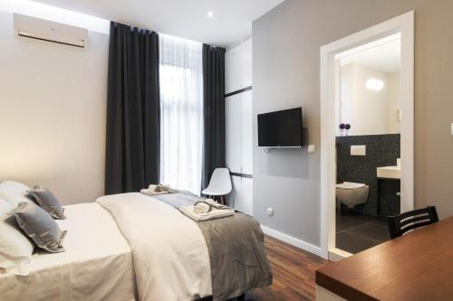 a bedroom with a bed and a table and a television at Prima Luxury Rooms in Split