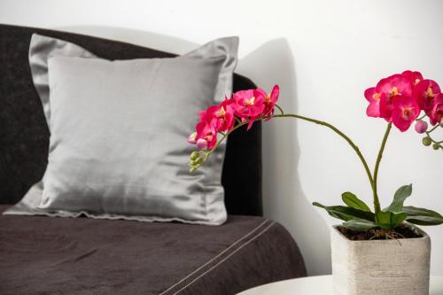 a vase with flowers on a table next to a couch at Prima Luxury Rooms in Split