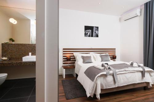 a bedroom with a large bed and a bathroom at Prima Luxury Rooms in Split
