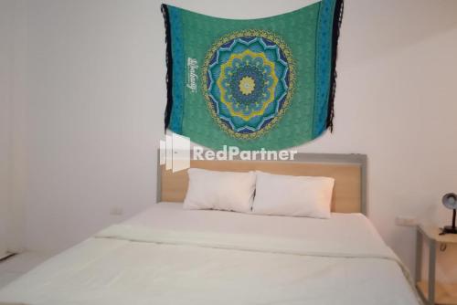 a bedroom with a bed with a banner above it at Pasifik Hotel Sabang Mitra RedDoorz in Sabong