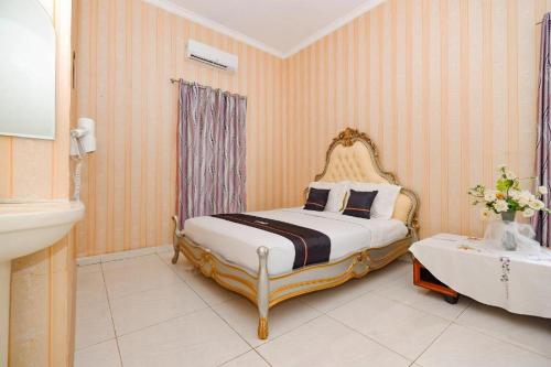sypialnia z łóżkiem typu king-size i umywalką w obiekcie Guest House Gethsemane w mieście Salatiga
