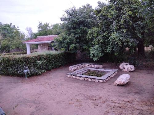 a garden with a stone bench in front of a house at Korta Escape- A Heritage Resort in Jawai in Korta