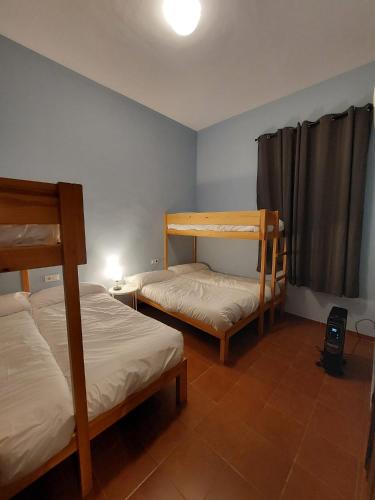 a bedroom with two bunk beds and a window at Casa Rural ESTACIÓN DEL SOLDADO in Estación del Soldado