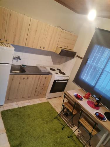 a small kitchen with wooden cabinets and a green rug at Country House in Sozopoli