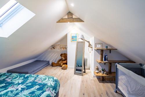 - une chambre mansardée avec un lit et un ours en peluche dans l'établissement Le Cocon Cancalais, à Cancale