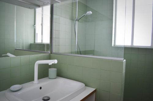 une salle de bain blanche avec un lavabo et un miroir dans l'établissement Appartement design avec terrasse, à Paris