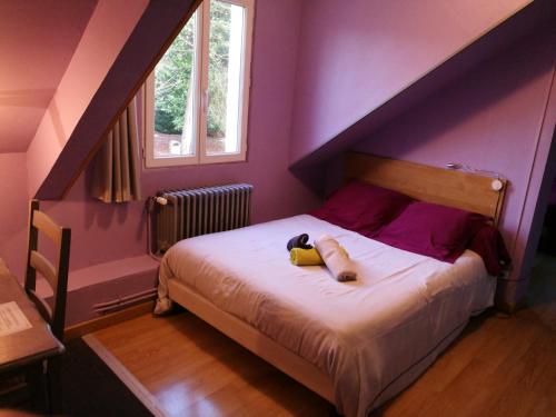a bedroom with a bed with purple walls at Auberge Normande in Valframbert