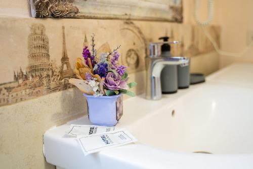 a vase of flowers sitting on top of a sink at Апартаменти дворівневі на віллі с садом in Kyiv
