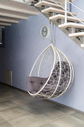 a white hanging hammock in a room with a clock at Апартаменти дворівневі на віллі с садом in Kyiv