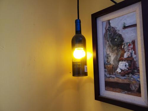 a light on a wall with a picture and a bottle at 墾丁愛情海民宿 in Kenting