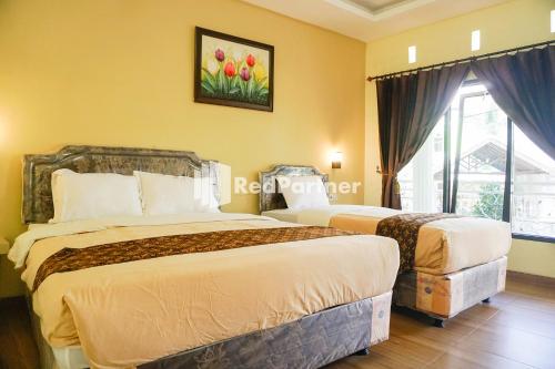 Postel nebo postele na pokoji v ubytování Griya Imafa Inn RedPartner near Jatim Park 2