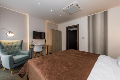 a bedroom with a bed and a chair and a desk at Penzion ZENIT in Prešov