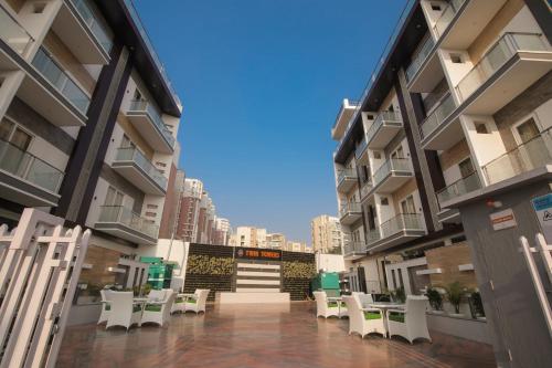 an empty courtyard of a building with white chairs at Pandora Twin Towers in Greater Noida