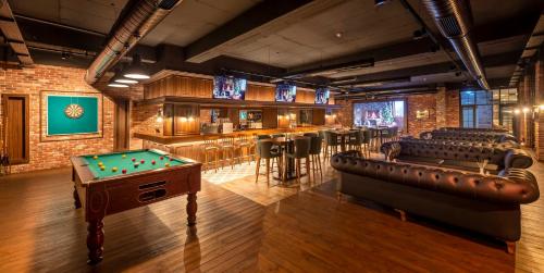 a billiard room with a bar and a pool table at Novel Centre Point Hotel in Mağusa