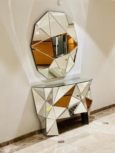 a mirror on a wall next to a table at Dedeman Erbil Hotel City Center in Erbil