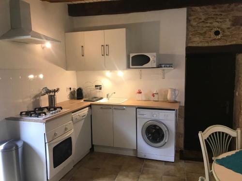 une cuisine avec un lave-linge et un lave-linge dans l'établissement Gîte Le Meynet, à Saint-Cyprien