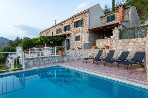 a villa with a swimming pool in front of a house at Village house Ana Dubravica in Dubravica
