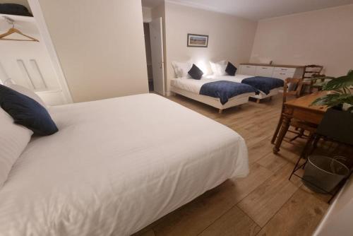 a bedroom with two beds and a table and a desk at Le Rodin Bazas in Bazas