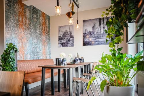 a dining room with a table and chairs and a couch at Slot Hotel Schagen in Schagen