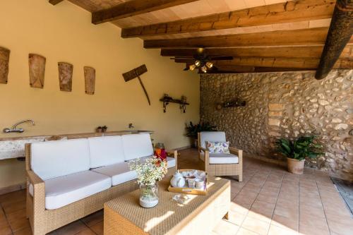 sala de estar con sofá y pared de piedra en Villa FRARE, en Búger