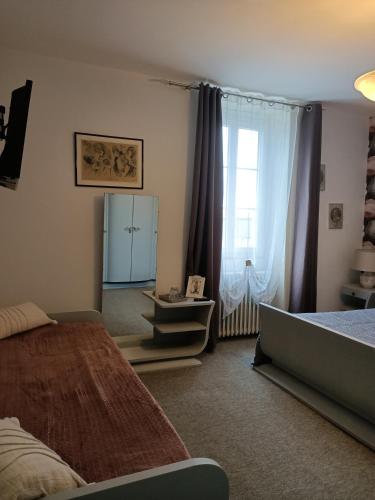une chambre avec deux lits et une grande fenêtre dans l'établissement La Morgiane, à Saint-Germain-les-Vergnes