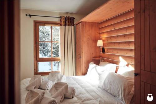 a bedroom with a large white bed with a window at Tartiflat, Arc1950, 2 bed, Ski in Ski out, Arc 1950 in Bourg-Saint-Maurice