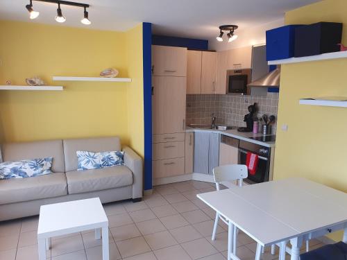 a living room with a couch and a table at Oostduinkerke Apartments in Oostduinkerke