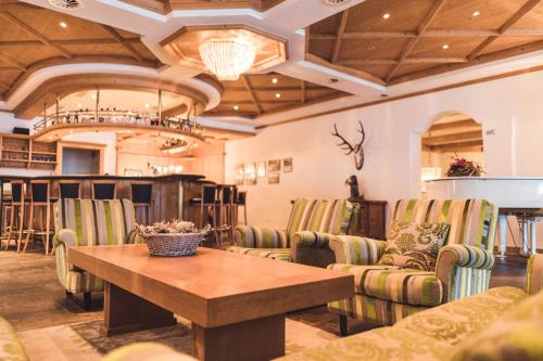 a room with chairs and a wooden table and a table at Posthotel Valbella in Valbella