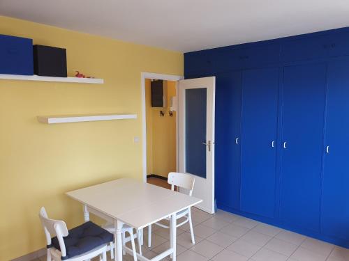 a dining room with a white table and blue cabinets at Oostduinkerke Apartments in Oostduinkerke