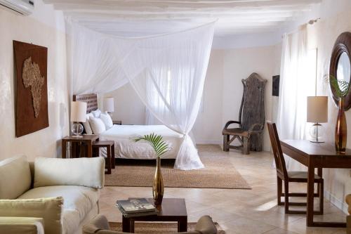 Lion in the Sun Billionaire Retreat Malindi في ماليندي: غرفة معيشة مع سرير وأريكة