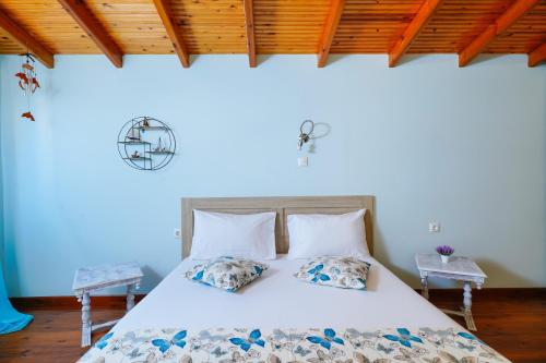 a bedroom with a bed with white sheets and pillows at il giardino in Skala Kallirakhis