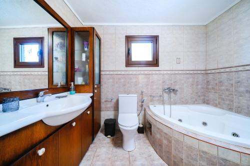 a bathroom with a tub and a toilet and a sink at il giardino in Skala Kallirakhis