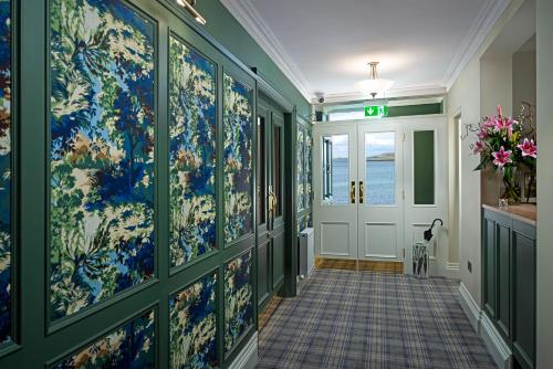a hallway with a wall of blue and white wallpaper at Monks Ballyvaughan in Ballyvaughan