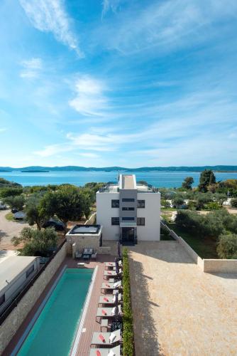 a pool with lounge chairs next to a building at Villa Marija in Sveti Filip i Jakov
