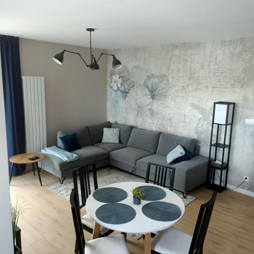 a living room with a couch and a table at Apartament PERŁA POŁUDNIA in Suwałki
