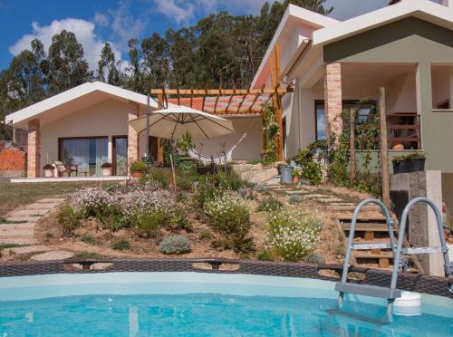 a house with a swimming pool in front of a house at Casa Limonina in Louriçal