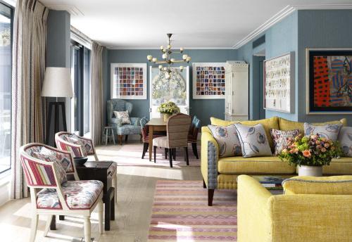 ein Wohnzimmer mit einem gelben Sofa und einem Tisch in der Unterkunft Ham Yard Hotel, Firmdale Hotels in London