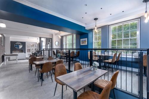 a restaurant with blue walls and tables and chairs at The Northwick Arms Hotel in Evesham