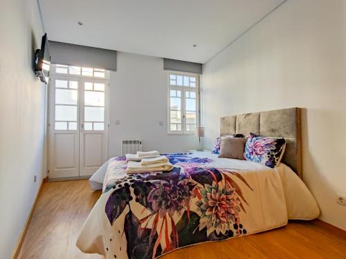 維亞納堡的住宿－São Domingos Apartment - Viana City Centre，一间卧室配有一张大床和色彩缤纷的毯子