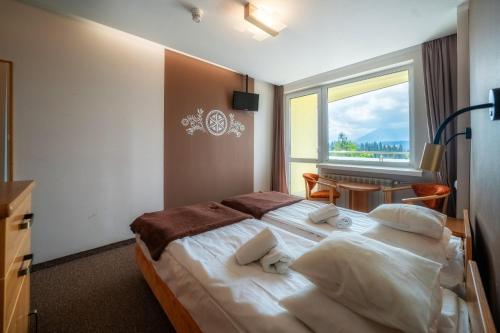 a hotel room with a bed and a window at Rysy in Bukowina Tatrzańska
