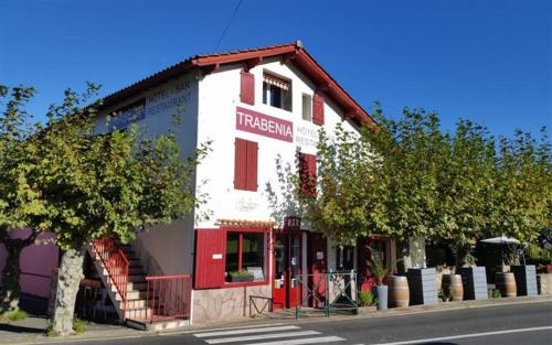 a red and white building on the side of a street at Auberge Trabenia in Ascain