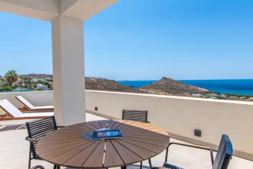 a table and chairs on a balcony with the ocean at Blue Gres Villa Tinos in Tinos Town