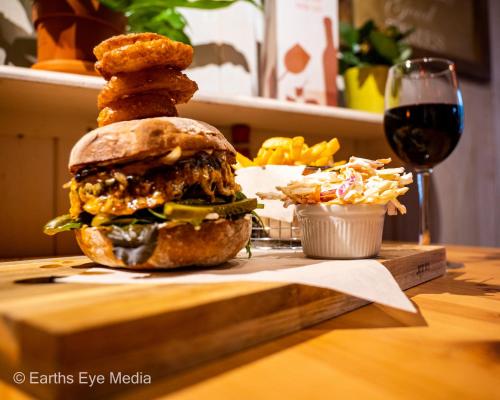 a sandwich on a wooden table with a glass of wine at The Bear Inn in Llandovery