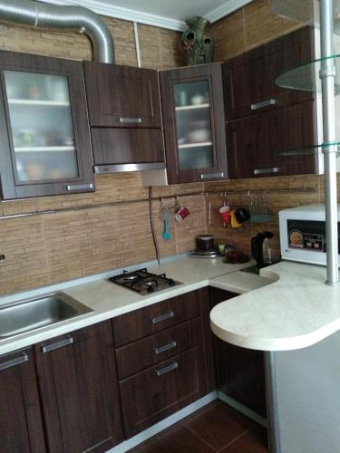 - une cuisine avec des placards en bois et un comptoir dans l'établissement 2-x Apartments Center Wi-Fi около Площади, à Tchernihiv
