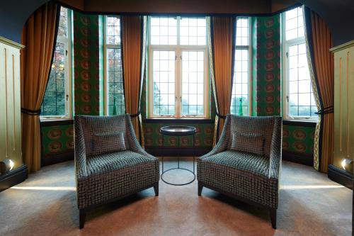 two chairs and a table in a room with windows at Aldwark Manor Estate in Aldwark